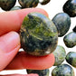 Lifestyle view of a Jade tumbled stone, sourced from Peru.
