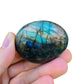 Held in palm of a Labradorite palm stone, from Atsimo-Andrefana, Madagascar, associated with Manifestation, shown at hand scale.