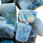 Macro view of Grade AA gray Labradorite tumbled stone, showing soft luster, hand-selected from Atsimo-Andrefana, Madagascar.