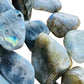Natural light view of a Labradorite tumbled stone, sourced from Atsimo-Andrefana, Madagascar.