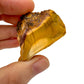 Hand-scale view of Mookaite stone, associated with Adventure, shown alongside the hand for scale.