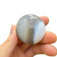 Scale reference of a single Orca Agate palm stone Madagascar-sourced.