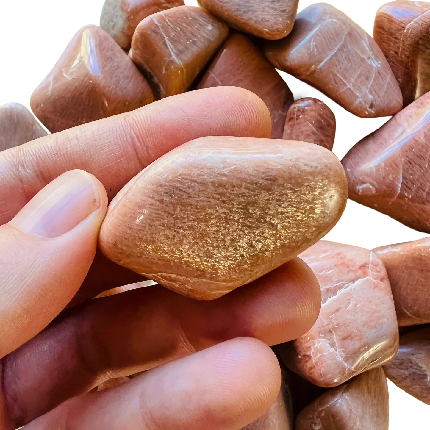 Lifestyle view of a Peach Moonstone tumbled stone, sourced from Alaotra-Mangoro, Madagascar.