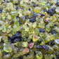 Size comparison with one Peridot raw stone for scale, United States-sourced.