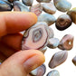 Resting display of Pink Agate tumbled stone, showing natural surface character.