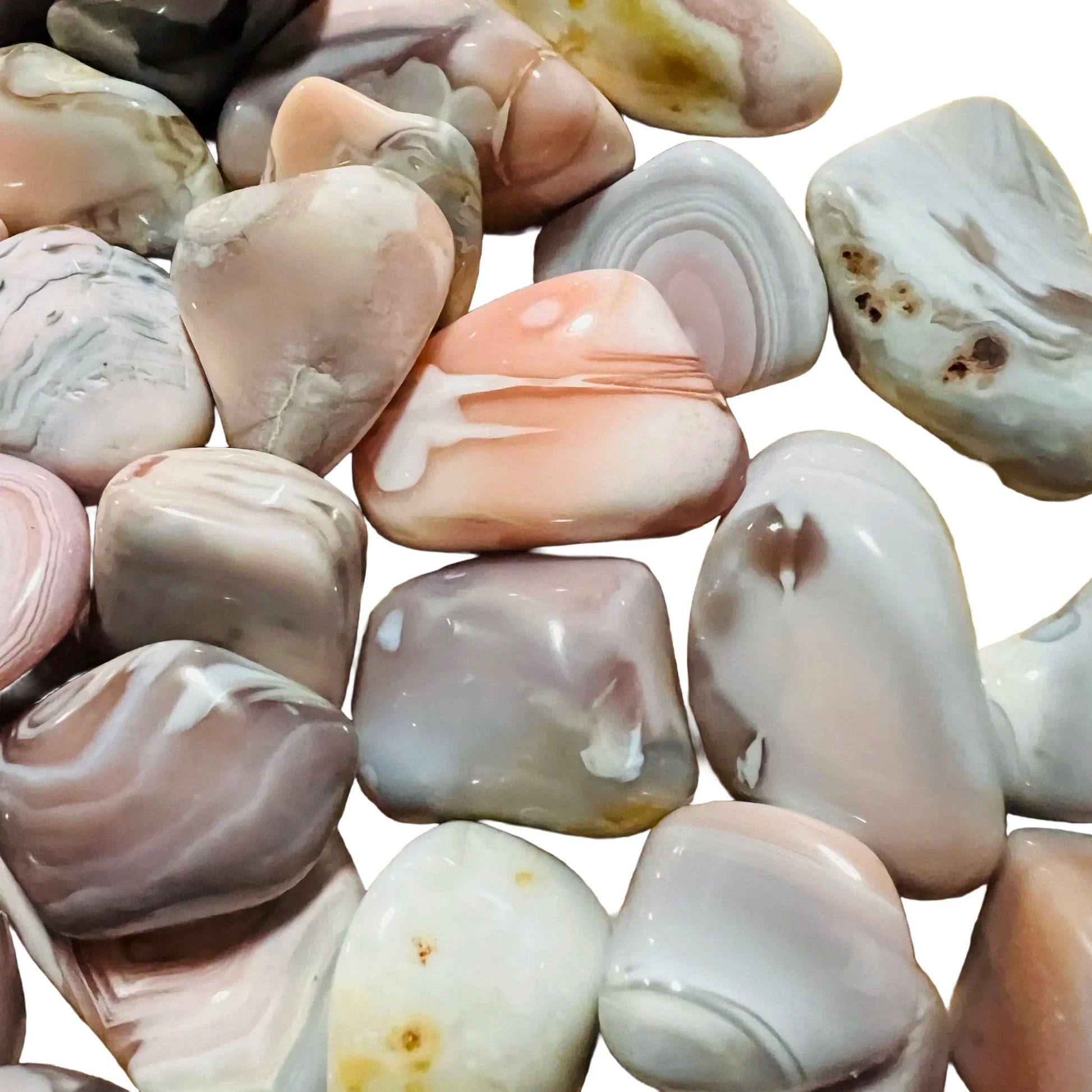 Hand-held view of a Pink Agate tumbled stone often worked with for Love and Self Love, from Botswana.