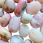 Sideways view of Pink Opal tumbled stone, showing characteristic color, to support Love.