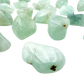 Close grouping of Prehnite tumbled pieces (1-1.50 Inch, 10-30g) showing pale green to yellow-green color range