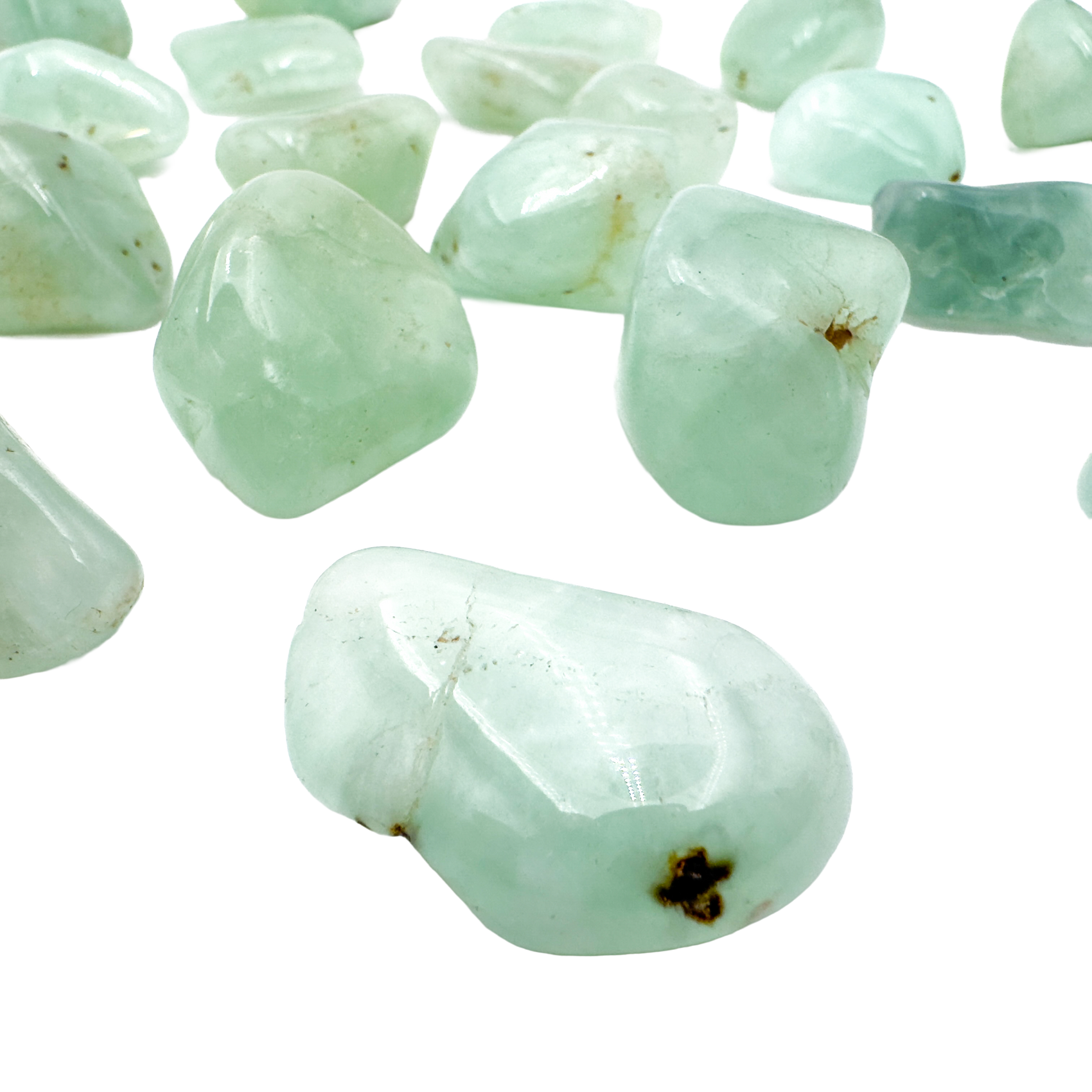 Close grouping of Prehnite tumbled pieces (1-1.50 Inch, 10-30g) showing pale green to yellow-green color range