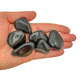 Lifestyle still of Rainbow Obsidian tumbled stone, showing the full body of the piece.