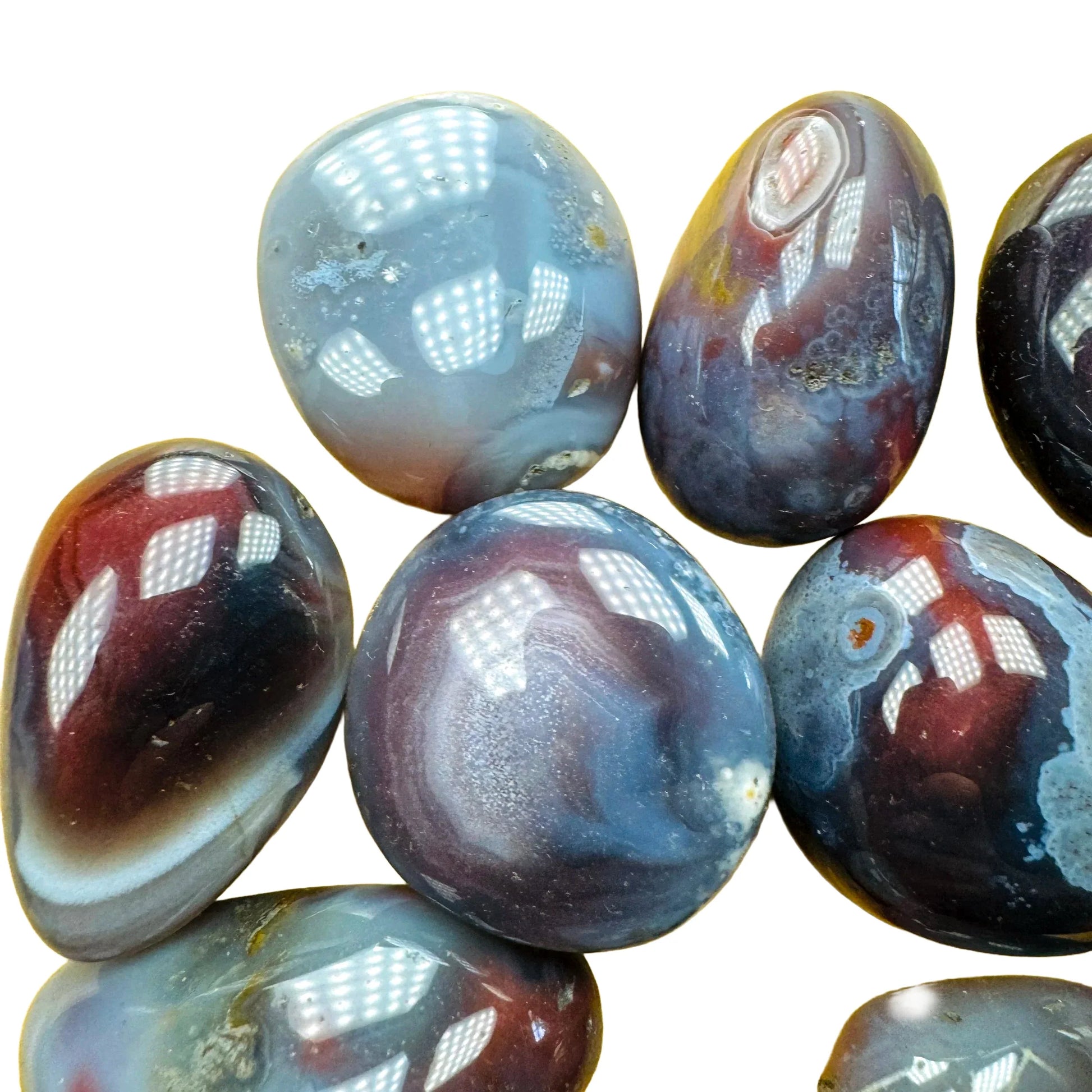 Detail shot of Grade AA Red Agate tumbled stone under natural light