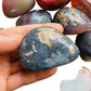 Composed shot of Red Agate palm stone, from Matabeleland South Province, Zimbabwe, often kept for Protection, shown for size reference.