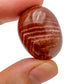 Field-of-view of Red Aragonite tumbled stone, from Junín, Peru, showing the piece in repose.