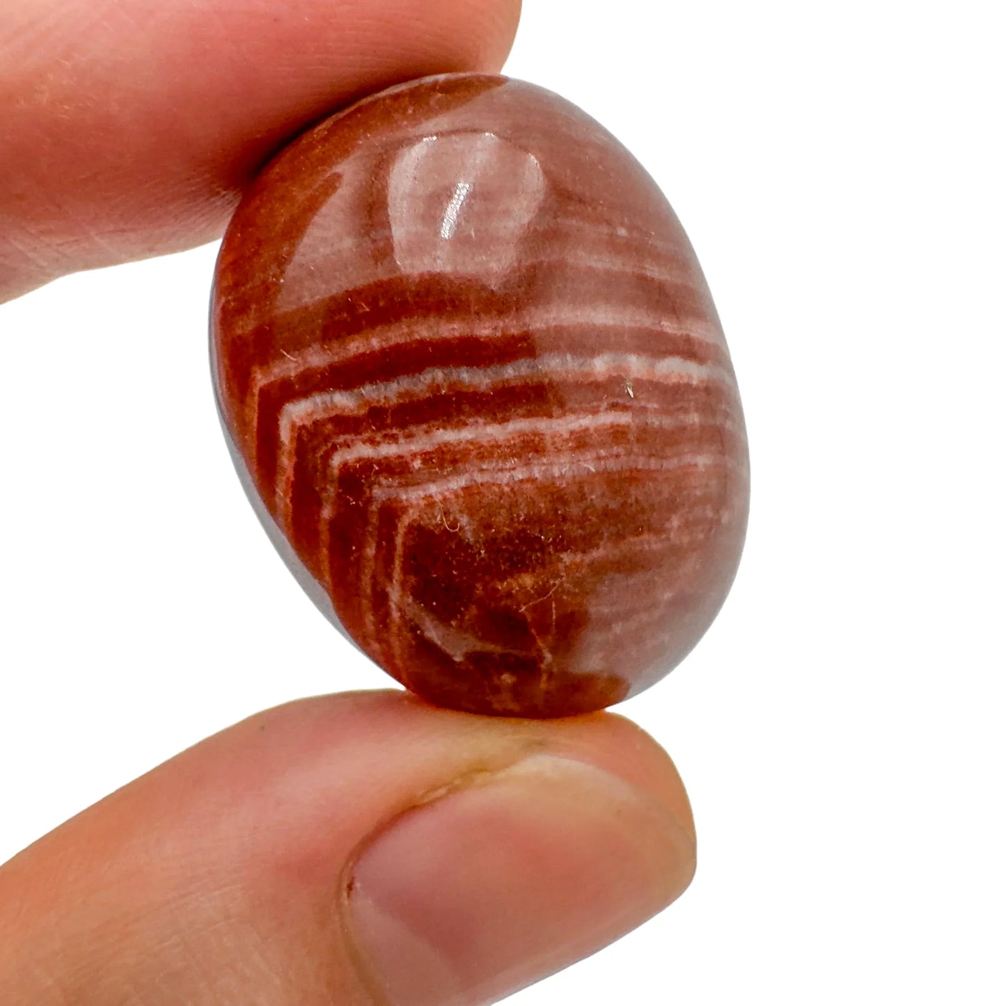 Field-of-view of Red Aragonite tumbled stone, from Junín, Peru, showing the piece in repose.