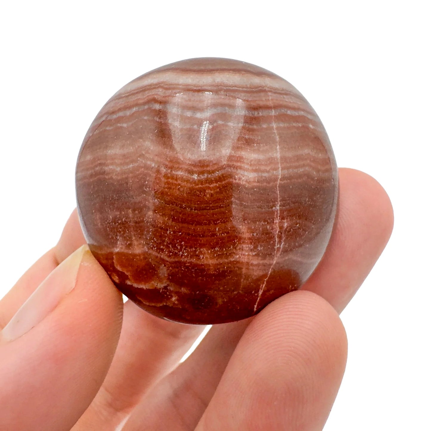 Detail shot of Grade AAA Red Aragonite tumbled stone under natural light