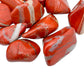 Edge-on view of Grade AA Red Jasper tumbled stone, hand-selected from Northern Cape, South Africa, showing earthy tone.