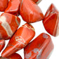 Hand-scale view of Red Jasper tumbled stone, with form visible in context.