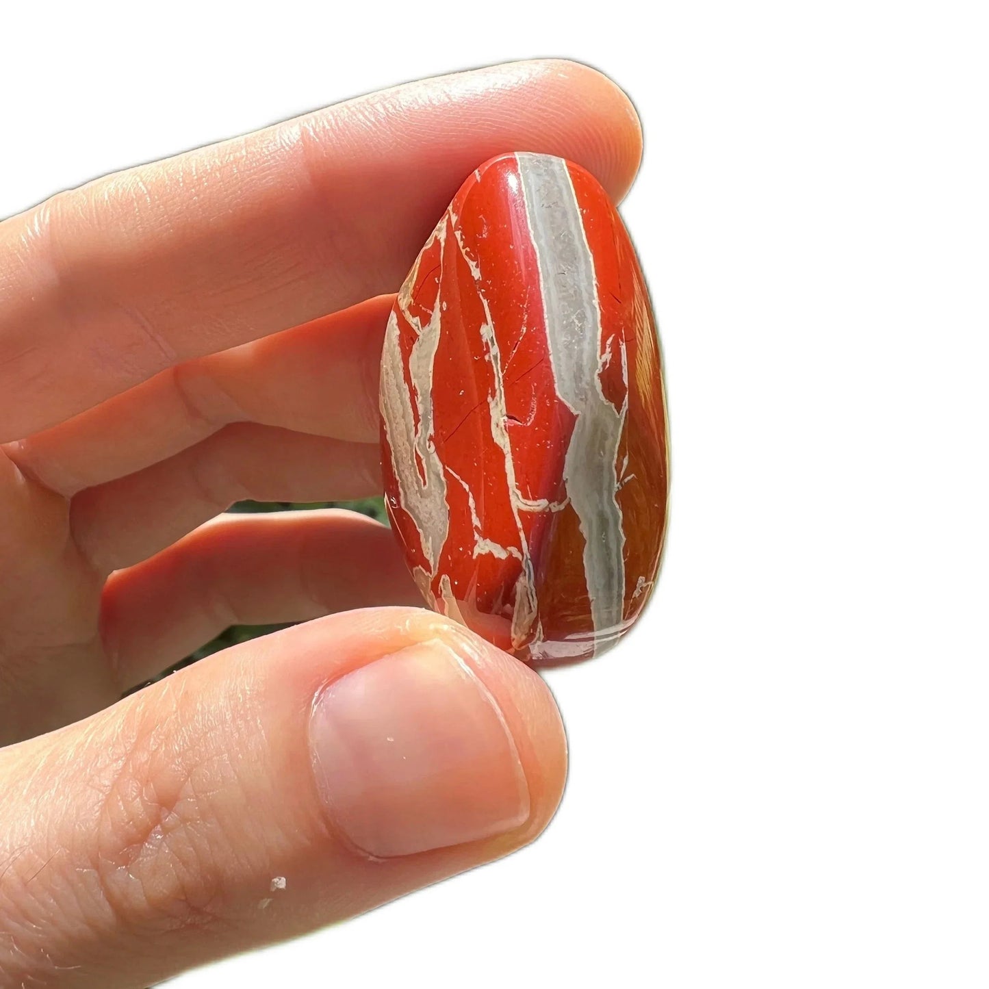 In-hand view of one Red Jasper tumbled stone for scale, sourced from South Africa.