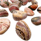 Top-down shot of Rhodochrosite tumbled stone, for Emotional Healing, sourced from Argentina.