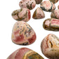 Daylight detail of Rhodochrosite tumbled stone, from Catamarca Province, Argentina, with surface texture in view.