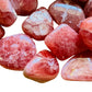 Near view of Grade AA pink Rhodochrosite tumbled stone, showing natural variation, often kept for Emotional Healing.