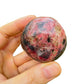 Scale comparison of Rhodonite stone, traditionally used for Love, showing natural surface character.