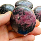 Top-down shot of Rhodonite palm stone, showing translucent edges.