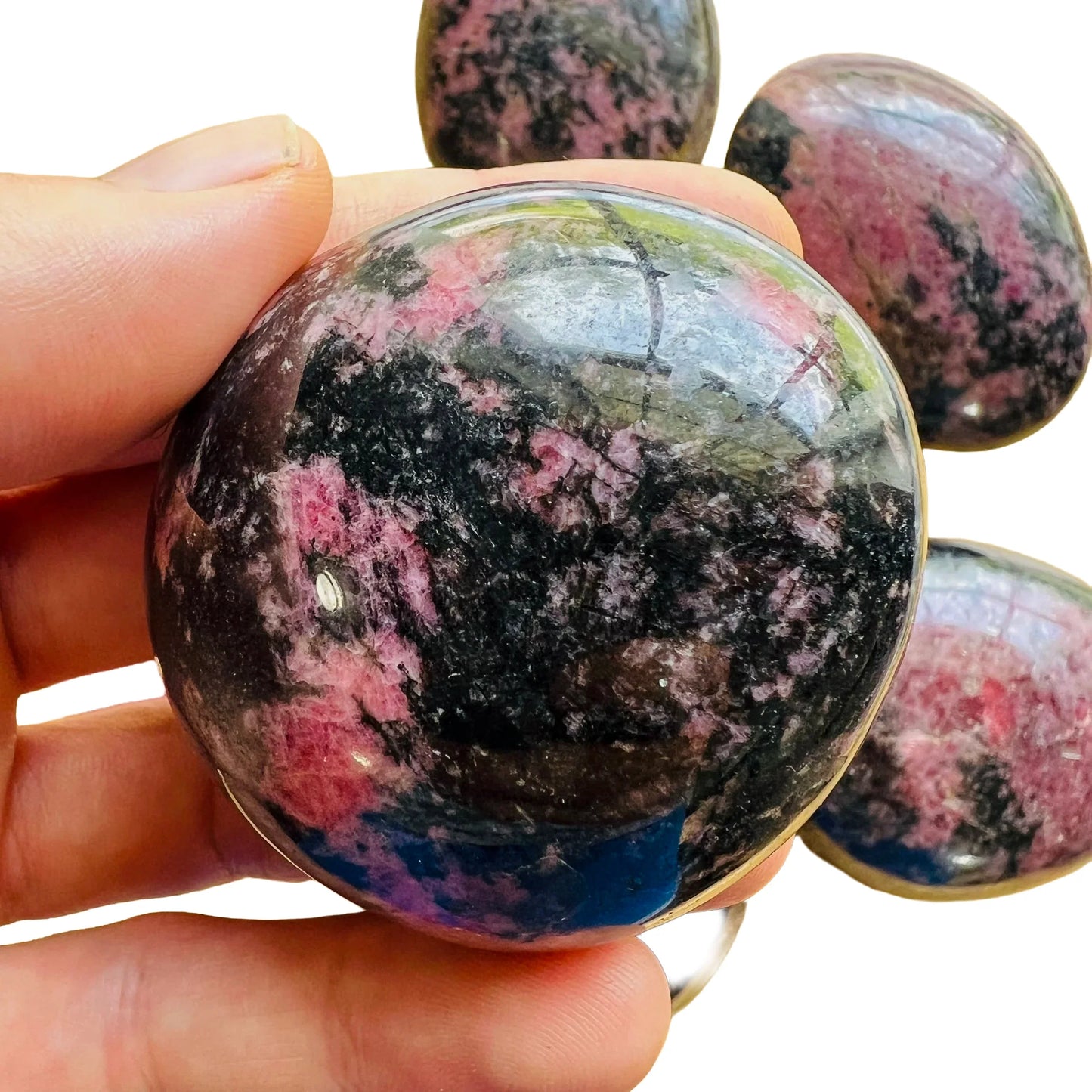 Reverse angle of Rhodonite palm stone, from Madagascar, showing translucent edges.