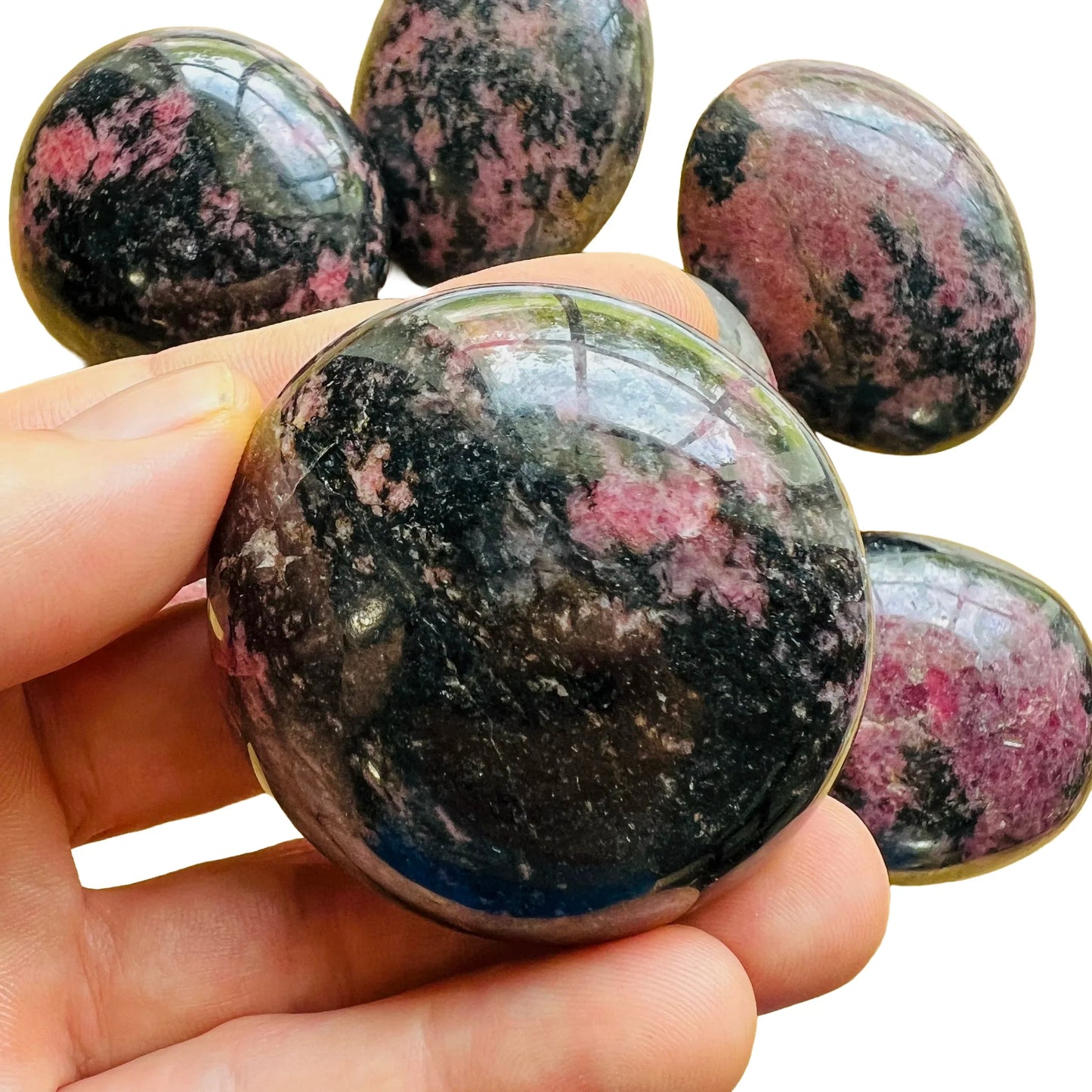 Daylight view of a Rhodonite palm stone worked with for Emotional Healing, from Madagascar.