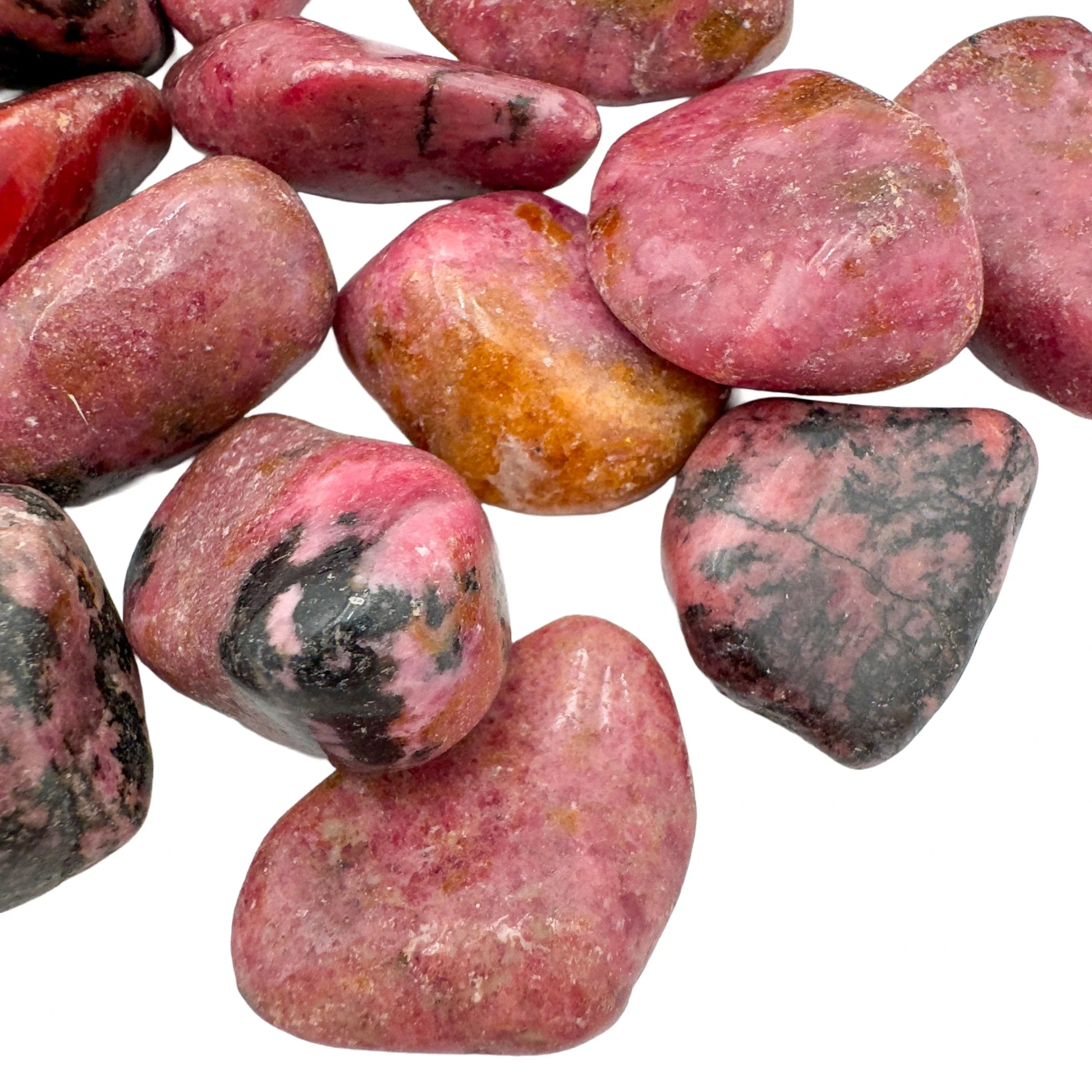 Bird's-eye view of Grade AA Rhodonite tumbled stone, showing natural texture.