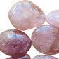 Natural light context of Rose Quartz palm stone, associated with Self Love, showing the full body of the piece.