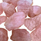 Side perspective of pink Rose Quartz raw stone, showing subtle veining.