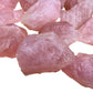 Considered view of Rose Quartz raw crystal, from Minas Gerais, Brazil, linked to Emotional Healing, with weight visible in the palm.