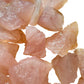 Texture-level view of pink Rose Quartz raw stone, showing natural inclusions, to support Love.