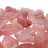 In-hand view of a single Rose Quartz tumbled stone sourced from Brazil.