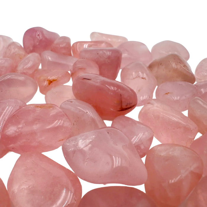 In-hand view of a single Rose Quartz tumbled stone sourced from Brazil.
