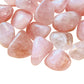 Edge-on view of Grade AA Rose Quartz tumbled stone, often kept for Love and Self Love, from Brazil.