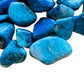 Sideways view of Chrysocolla tumbled stone, showing earthy tone.