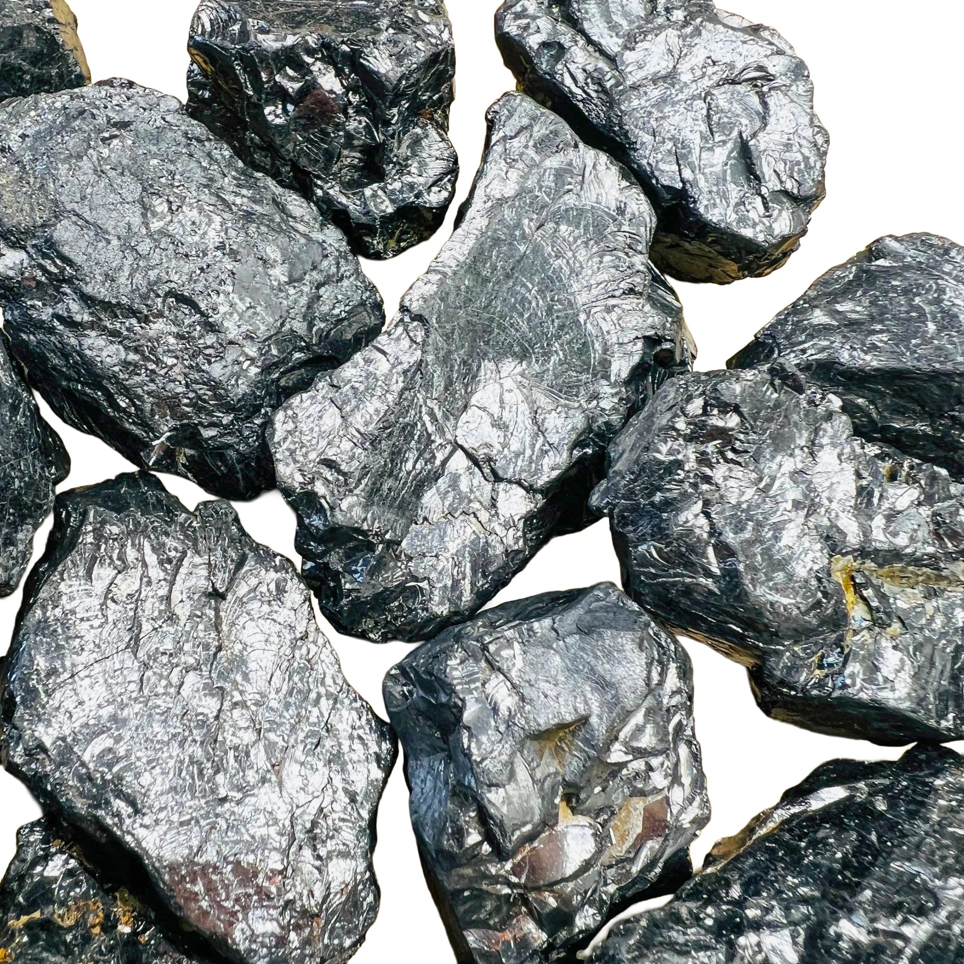 Held in hand, a Shungite raw stone held against natural backdrop, from Russia.