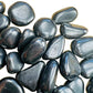 Reverse angle of Shungite tumbled stone, Russia-sourced, often paired with practices around Protection.