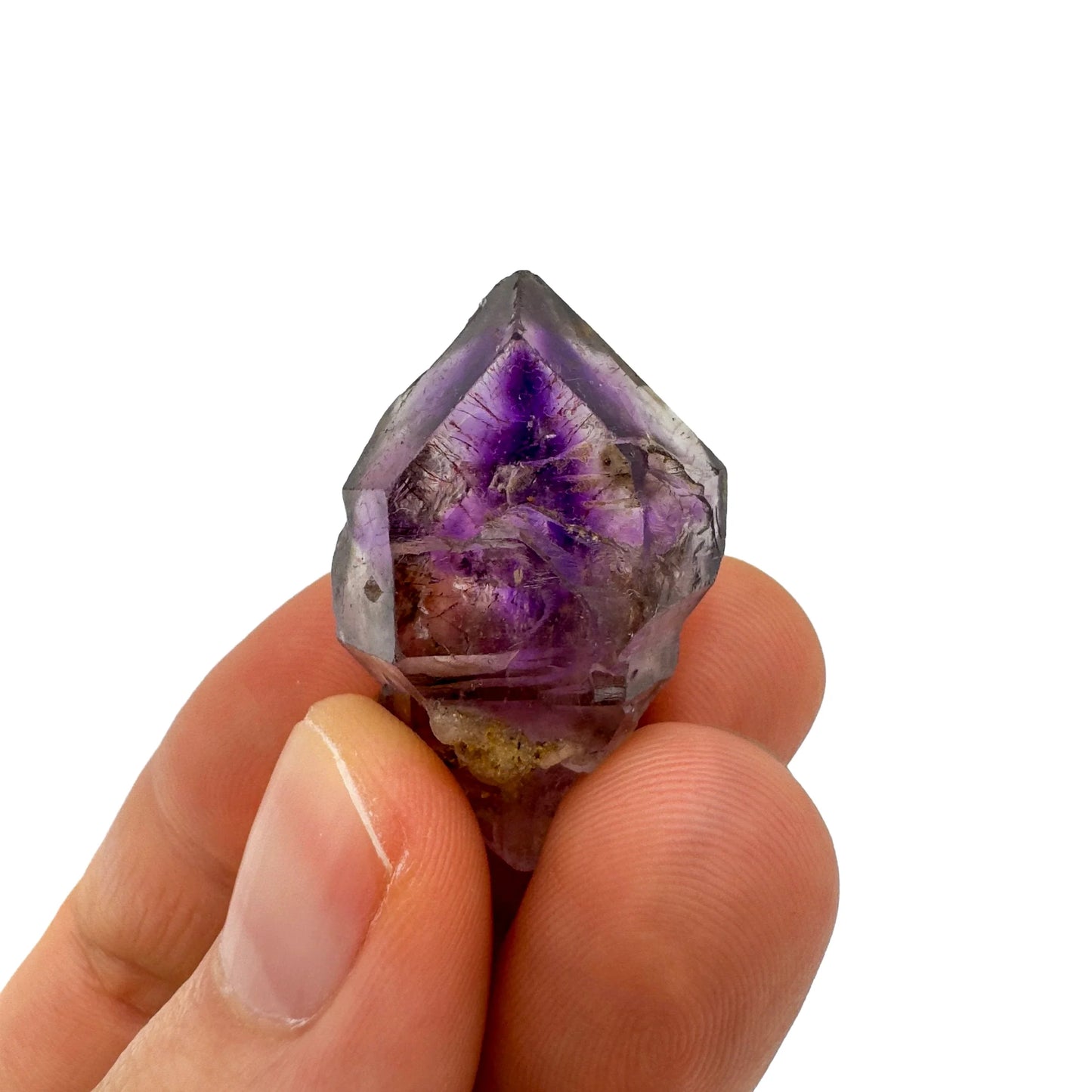 Hand-held view of a Smoky Amethyst raw point kept near for Grounding and Stress Relief.