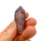 Considered view of Smoky Amethyst raw crystal, from Masvingo, Zimbabwe, shown alongside the hand for scale.