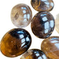Edge view of Grade AA Smoky Quartz palm stone, Madagascar-sourced.