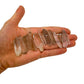 On a soft surface rests a Smoky Quartz raw crystal, from Minas Gerais, Brazil, often kept for Protection, with character of the piece on display.