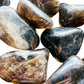 Scale reference of one Smoky Quartz tumbled stone for scale, Madagascar-sourced, sourced from Madagascar.