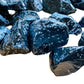 Hand-held view of a Snowflake Obsidian raw stone held against natural backdrop, United States-sourced.