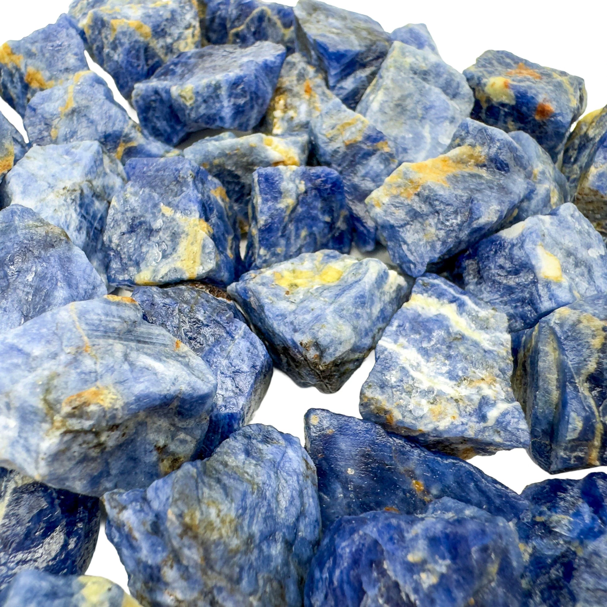 Lifestyle view of a Sodalite raw stone held against natural backdrop.