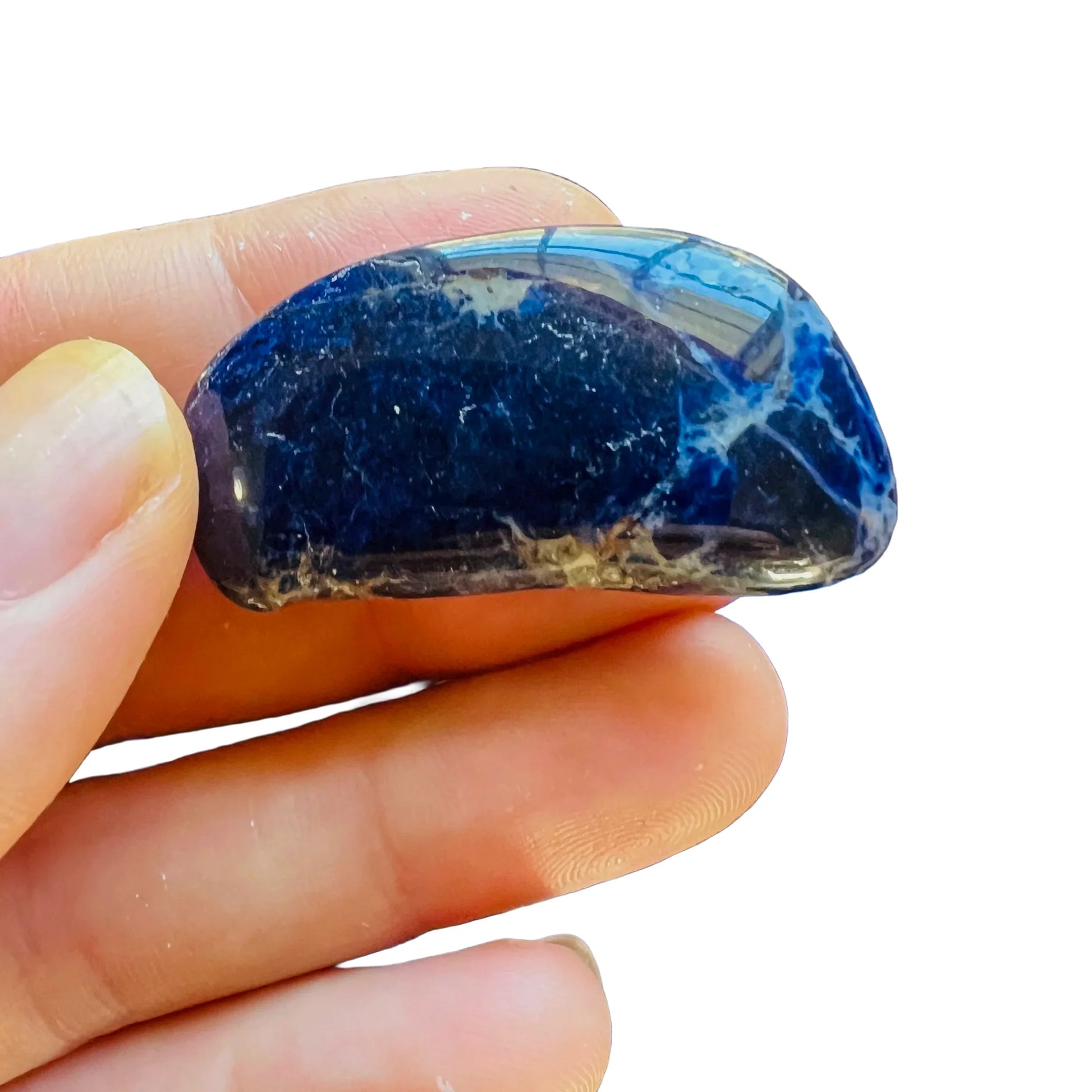 Detail shot of Grade AA Sodalite tumbled stone under natural light