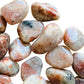 Reverse side of orange Sunstone tumbled stone, showing subtle veining, sourced from Morogoro, Tanzania.