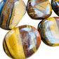 Close detail of brown Tiger Eye palm stone, often kept for Confidence and Career.